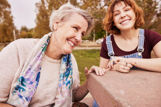 Elder person enjoying a day at the park with her family member sitting at a stone table