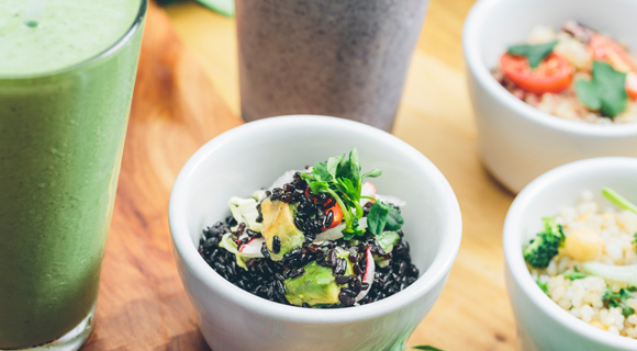 Bowls of grains and vegetables with glasses of smoothies
