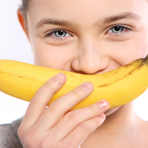 child smelling a ripe and healthy banana