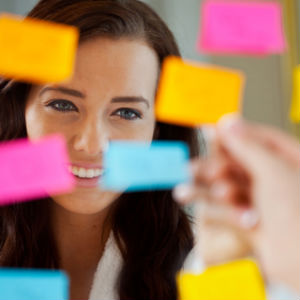 Woman smiling in mirror with sticky notes on it