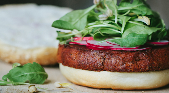 Burger topped with spinach and radishes