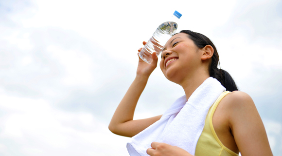 Smiling woman exercising with water bottle