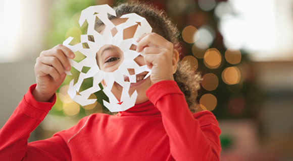 Girl holding paper snowflake