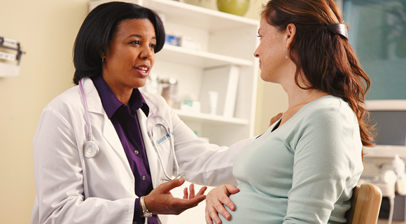 pregnant woman speaking with doctor