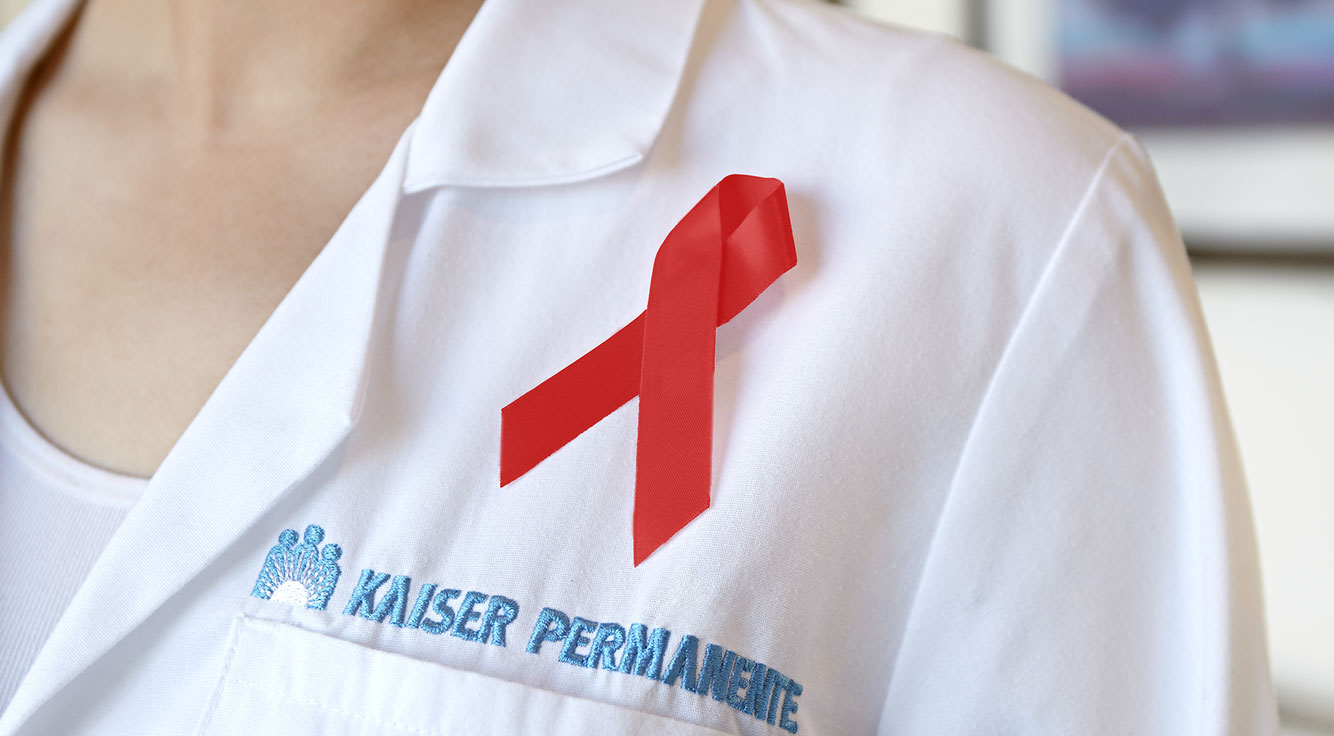 A red ribbon adorns a doctor's white coat.