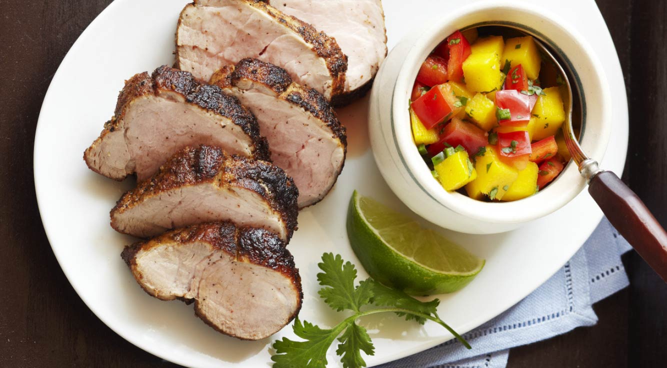 Plate of perfectly cooked pork with fresh mango salsa.