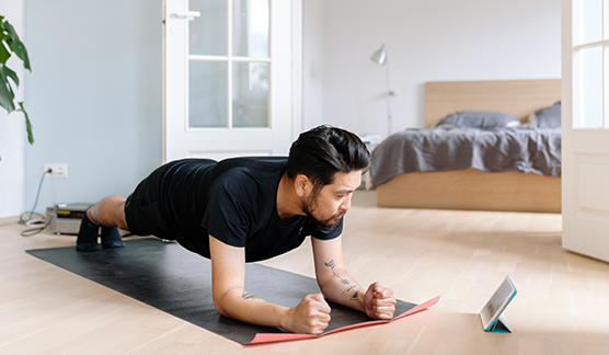 Man holds plank position on yoga mat