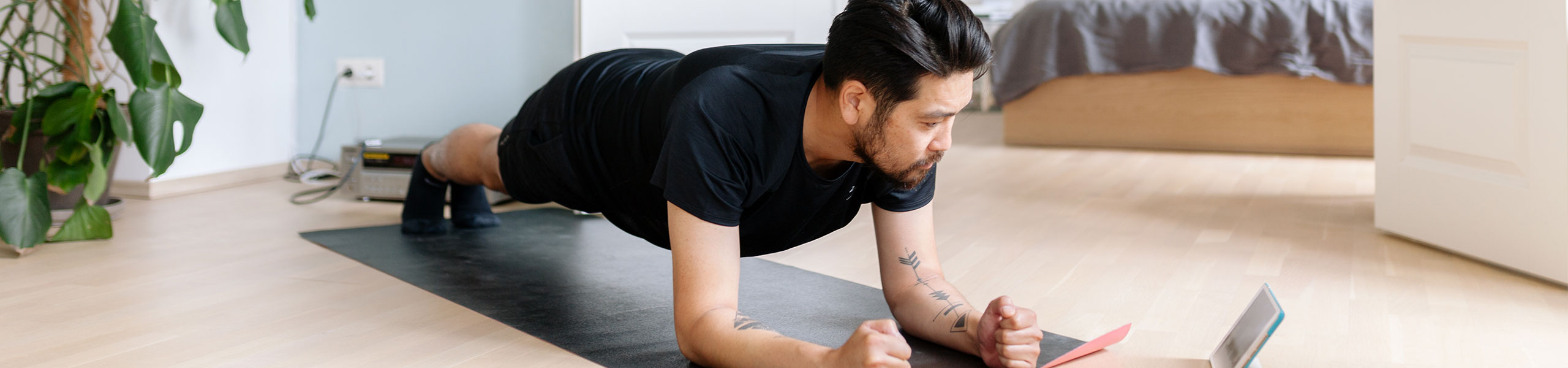 Man holds plank position on yoga mat