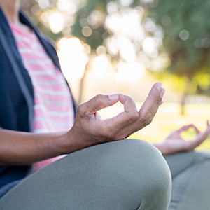 Woman sits outside in meditation pose