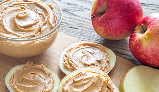 Healthy sliced apples topped with creamy peanut butter