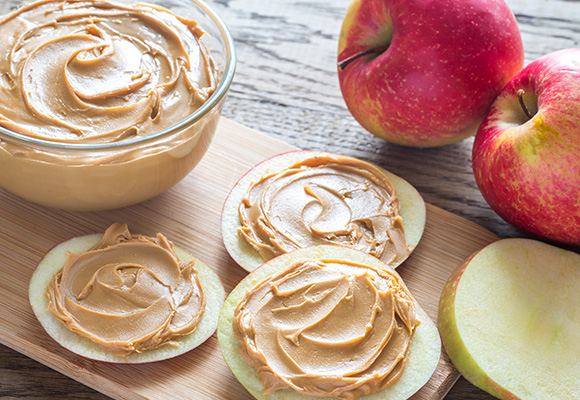 Healthy sliced apples topped with creamy peanut butter