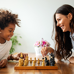 A smiling family plays chess