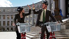 two people on bicycles highfiving