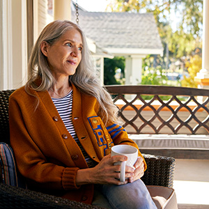 Smiling woman sits on front porch