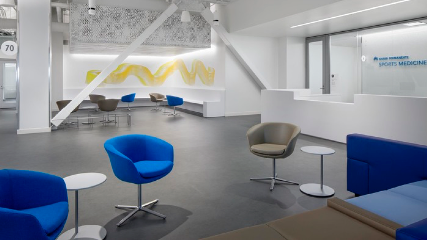 Modern, white dedicated reception and waiting area with blue and gray chairs